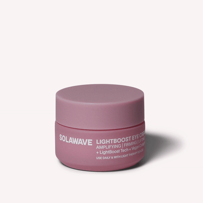 Un pot de crème pour les yeux LightBoost rose de Solawave est placé au centre d'un fond neutre, mettant en valeur sa technologie LightBoost et sa formule infusée de collagène végétal pour des propriétés amplificatrices et raffermissantes qui rehaussent votre routine de soins de la peau.